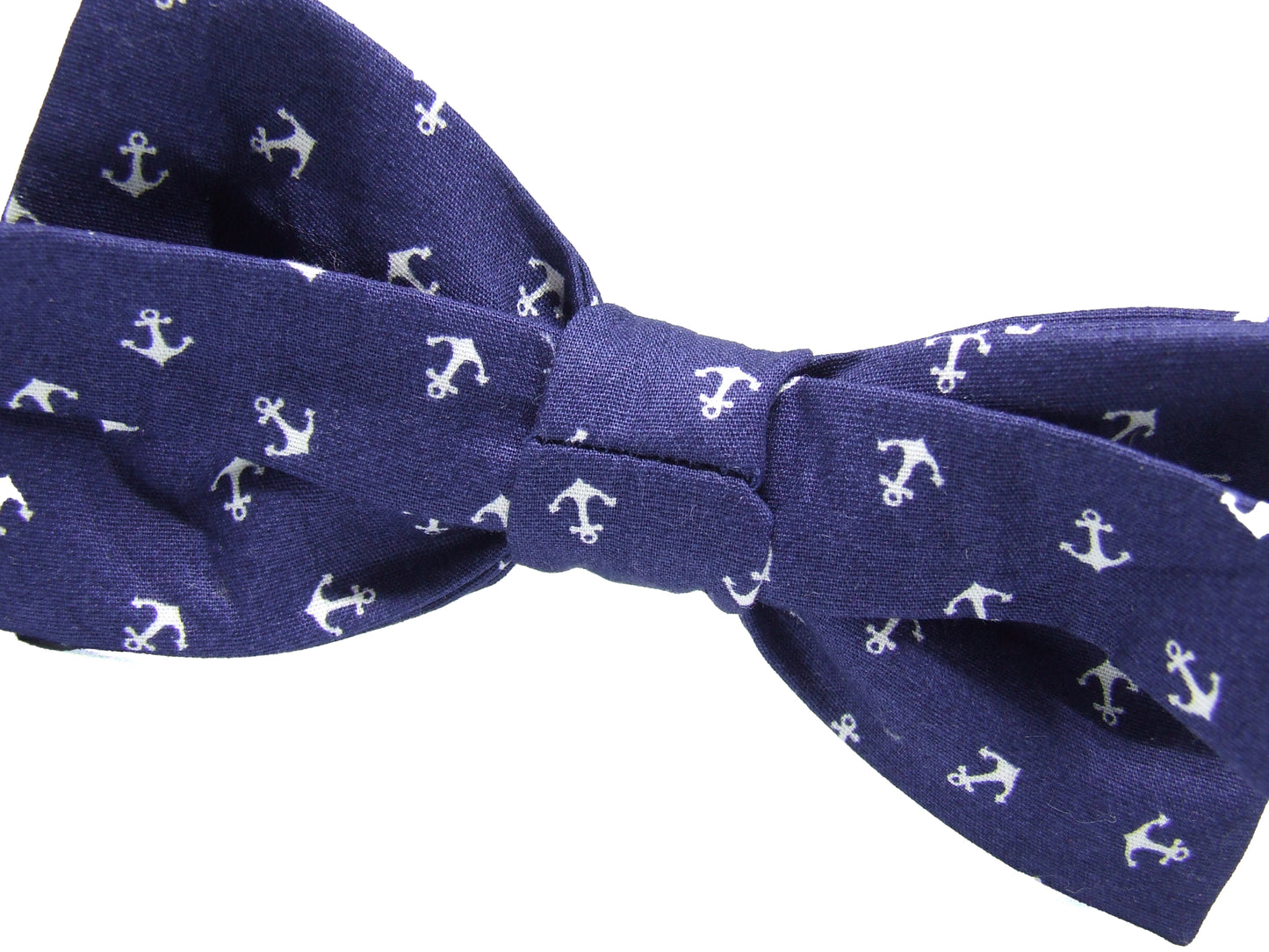 Achterkant van een donkerblauwe vlinderdas met witte ankers op een witte achtergrond